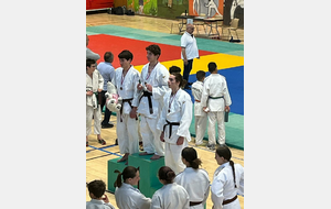 A l'arrière plan Mario, un des arbitres de la compétition. Au premier plan Maxime sur la 3ème marche du podium. (Marcy 2025).